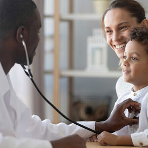 Doctor listening to a child's chest with a stethoscope while a mother watches