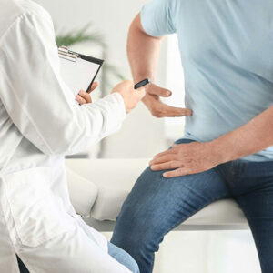 A patient pointing to his lower abdomen during a medical examination