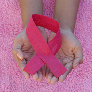 Photo of hands holding a pink ribbon